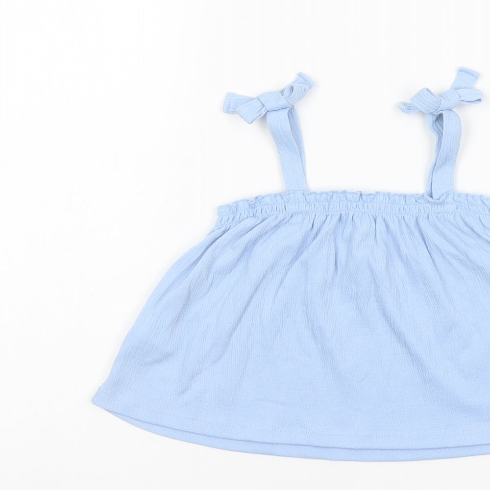 Brand and care label for H&M girls’ blue polyester basic blouse, size 3-4, years square neck pullover
