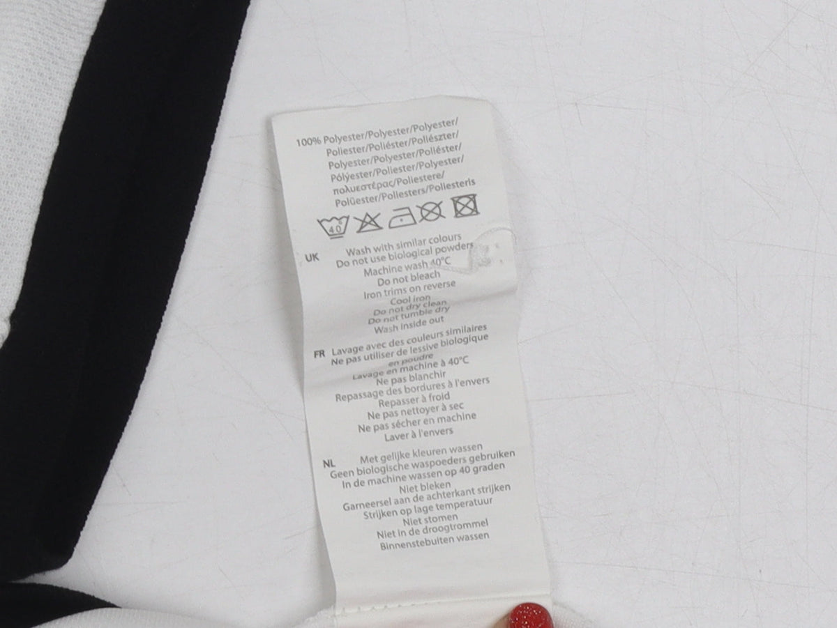Brand and care label for Slazenger boys’ white polo shirt, age 11-12, logo accent