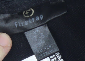 Brand and care label for Firetrap girls’' black athletic shorts 7-8 years