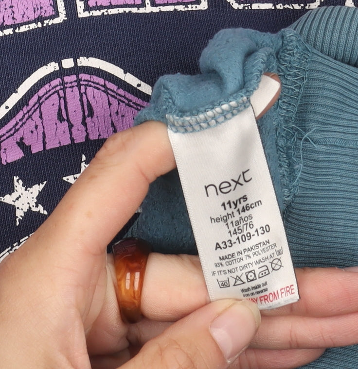 Brand and care label for Next girls’ blue graphic sweatshirt, 11 years