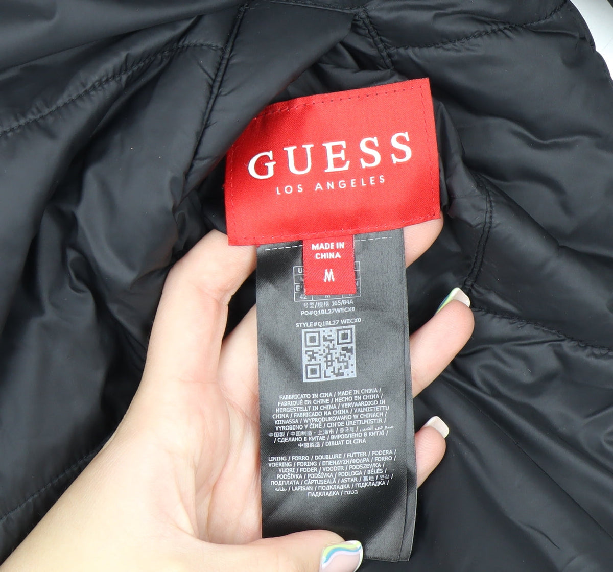 Brand and care label for Guess Men's Black Mid-Length Puffer Jacket, size M, with Stand-Up Collar
