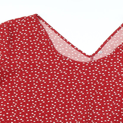 Close-up detail of Preworn women’s red basic blouse, size 2XL, - heart pattern