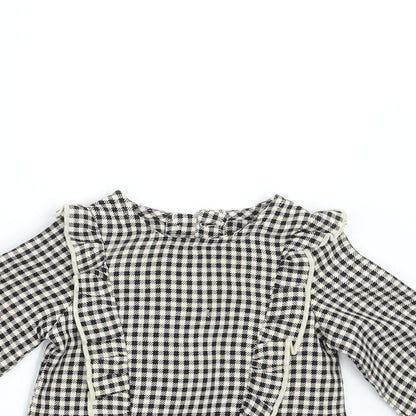 Close-up detail of Primark girls’ black check basic blouse, size 3-6, months