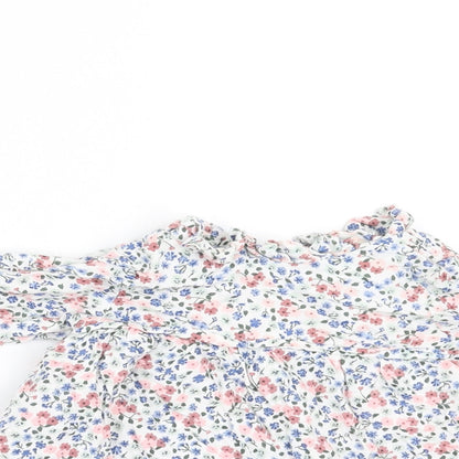 Close-up detail of Charanga girls’ white floral a-line, size 9-12, months