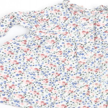 Brand and care label for Charanga girls’ white floral a-line, size 9-12, months