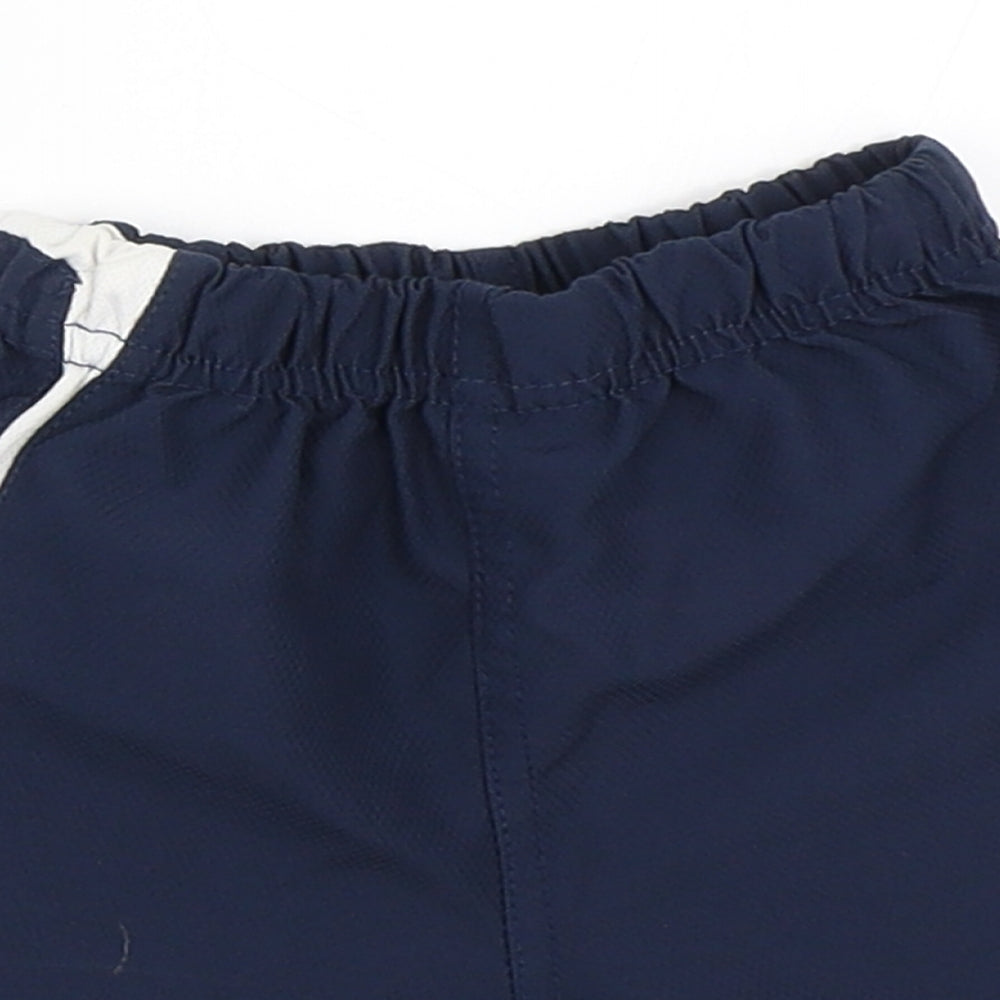 Close-up detail of Umbro boys’ blue cropped trousers, size 6-9, months - england football shorts