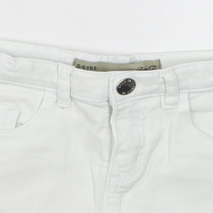 Close-up detail of Denim Co girls’ white denim cut-off shorts, size 5-6, years - pom pom