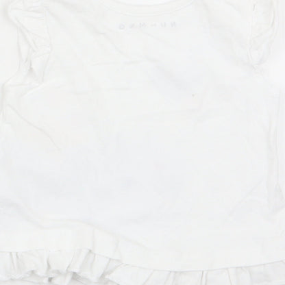 Brand and care label for Nutmeg girls’ white basic tank, size 3-6, months