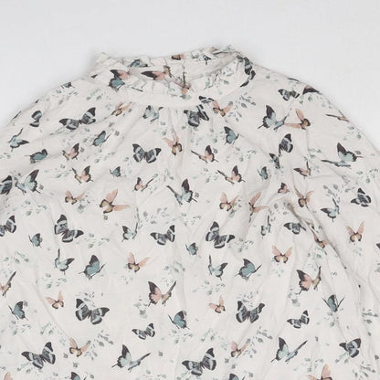 Close-up detail of Mango girls’ beige geometric viscose basic blouse, size 9, years mock neck button - butterfly pattern