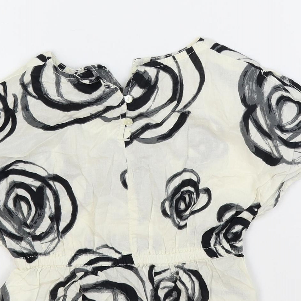 Brand and care label for Gap girls’ ivory floral cotton pullover blouse, size 18-24, months round neck button