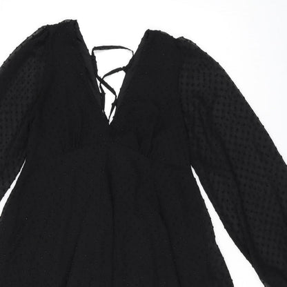 Close-up detail of ASOS women’s black polka dot polyester shift, size UK 10, v-neck zip