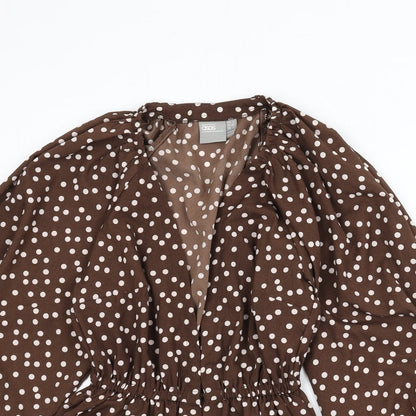 Close-up detail of ASOS women’s brown polka dot polyester basic blouse, size UK 4, v-neck - balloon sleeves