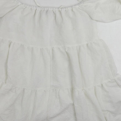 Brand and care label for In the Style women’s white polyester mini, size UK 10, off the shoulder pullover