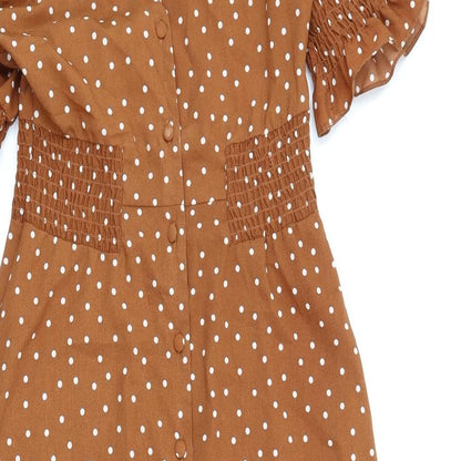 Close-up detail of ASOS women’s brown polka dot polyester a-line, size UK 8, v-neck button