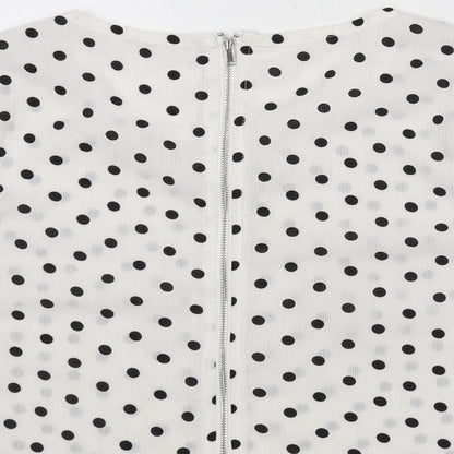 Brand and care label for Missguided women’s white polka dot polyester cropped blouse, size UK 8, round neck