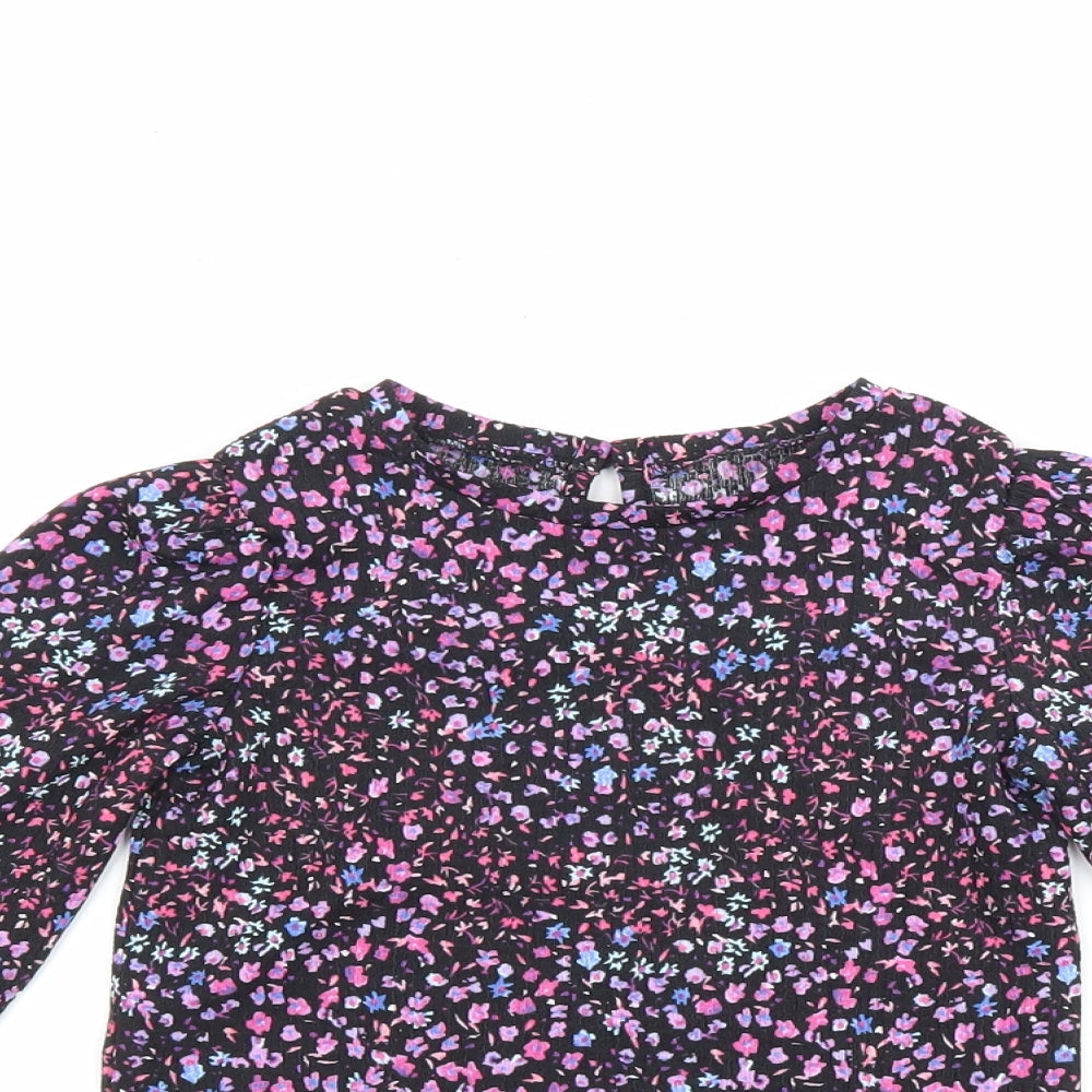 Close-up detail of Dunnes girls’ black floral polyester basic blouse, size 4-5, years round neck button