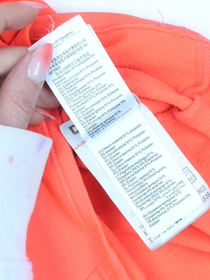 Brand and care label for Decathlon girls’ orange 1/4 zip sweatshirt, 5-6 years, lightweight