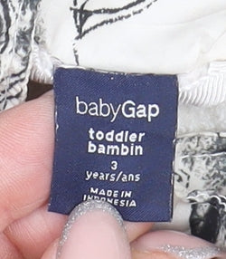 Close-up detail of Baby Gap girls’ ivory animal print puffer jacket, size 3