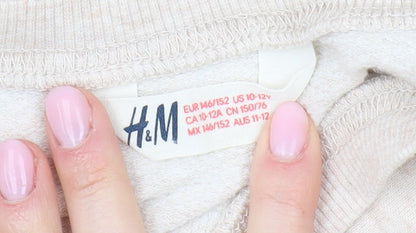 Close-up detail of H&M girls’ beige sequin shine bright sweatshirt 18 plus pullover