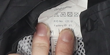 Brand and care label for the Rainsuit Shop boys’ black waterproof rain coat 11-12