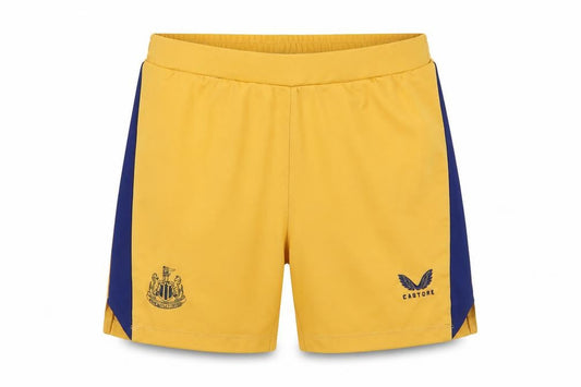 Front view of Castore boys’ gold athletic football shorts l