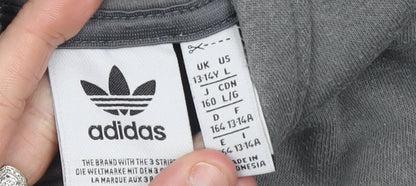Brand and care label for Adidas boys’ grey pullover hoodie, size 13-14, years cotton blend