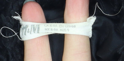 Brand and care label for H&M girls’ black fleece basic coat 8-9 years lined winter outerwear
