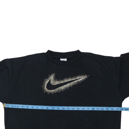 Close-up detail of Nike girls’ black gold logo xl sweatshirt crew neck pullover