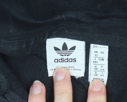 Brand and care label for Adidas women’s black hoodie, size UK 12, pullover cotton blend casual