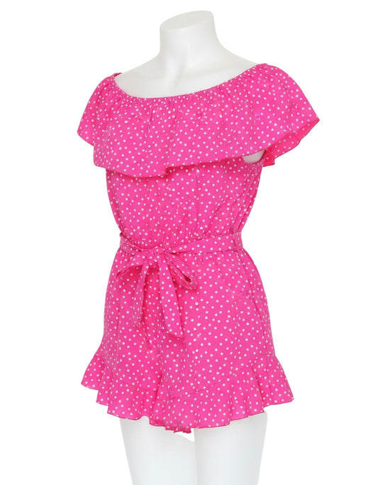 Prewornwholesale pink polka dot off-shoulder playsuit with ruffle neckline, belted waist, and ruffled hem shorts.