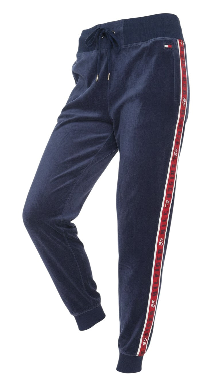 Prewornwholesale Tommy Hilfiger blue velour joggers with red side stripe branding and elasticated drawstring waist.